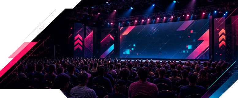 A packed game development conference audience facing a neon-lit stage.